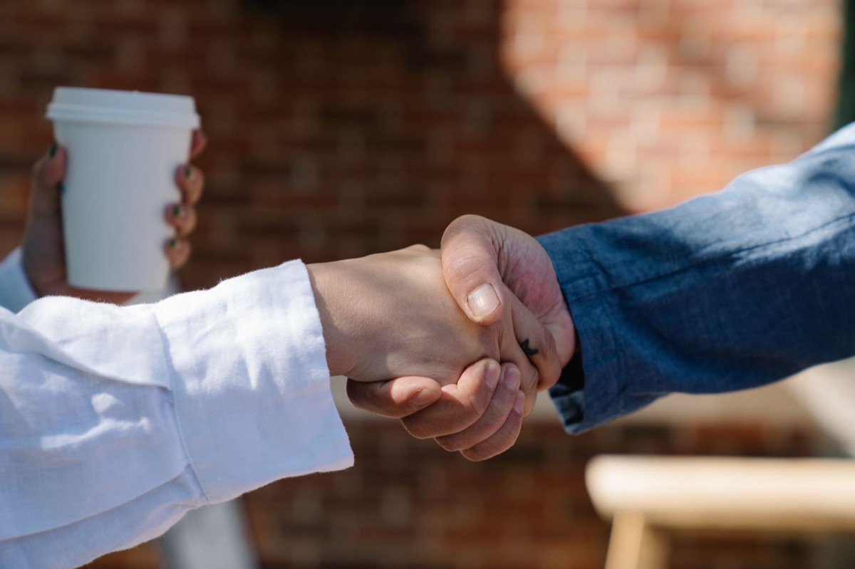 Dutch person shaking hand with another person